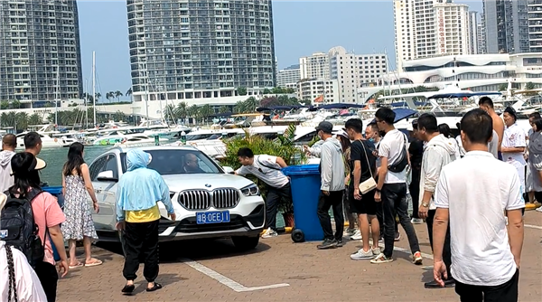 三亚一宝马车倒车失误 众目睽睽之下不慎掉入海中